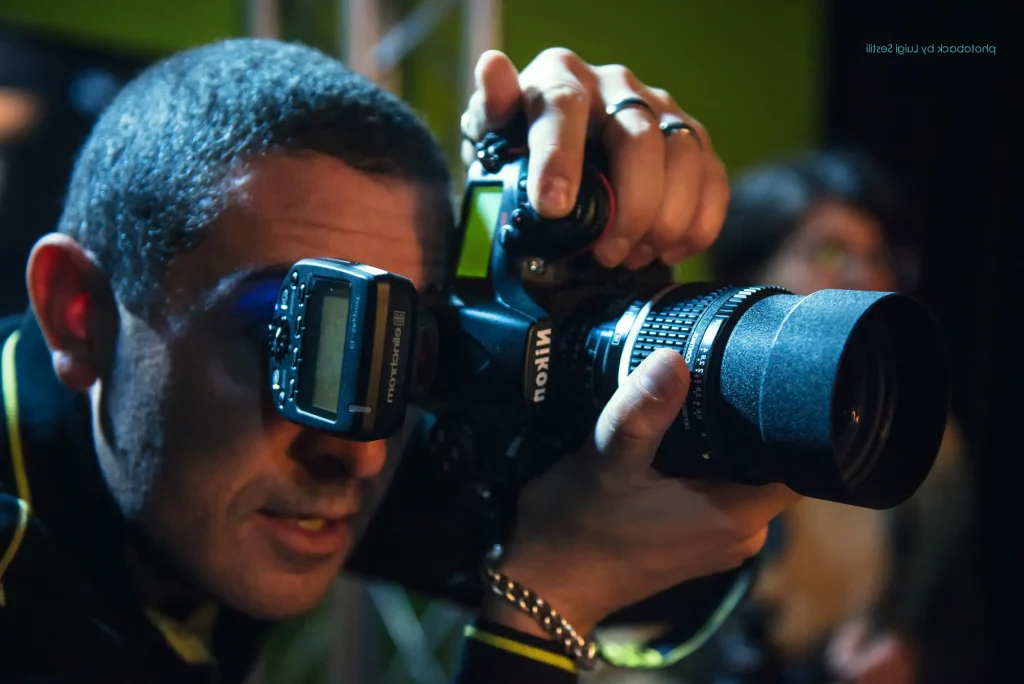 Francesco Francia in azione con una fotocamera Nikon, ritratto ravvicinato mentre scatta una foto.