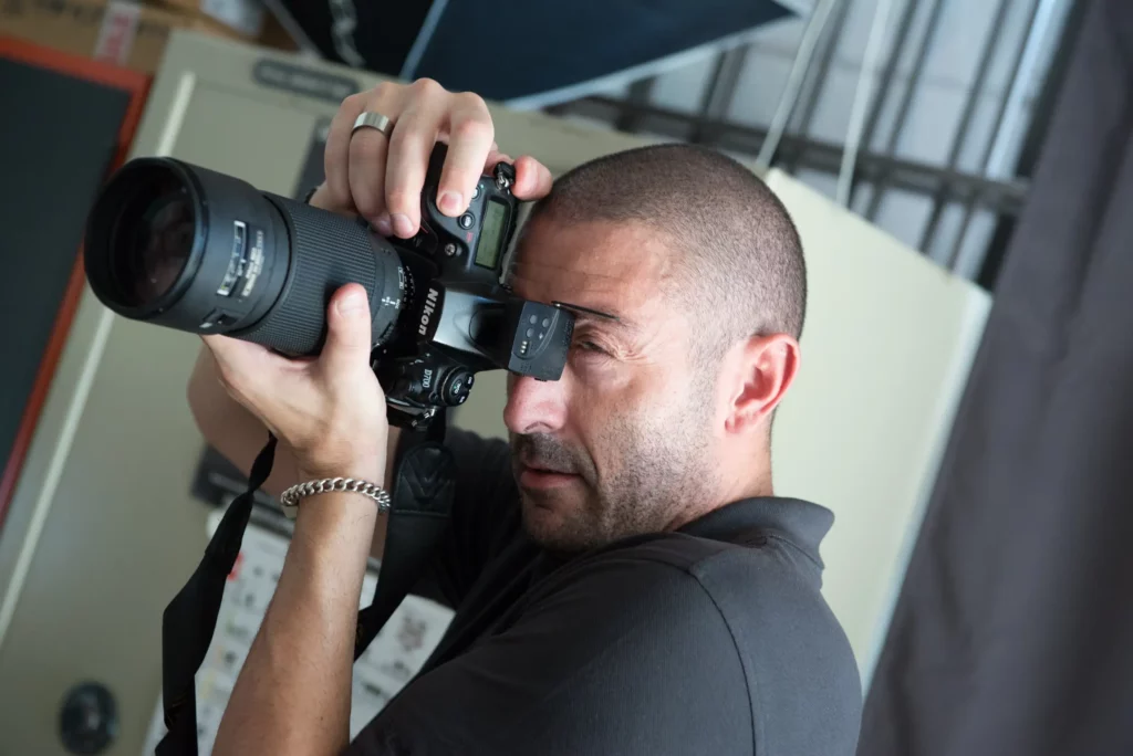 Francesco Francia fotografa in primo piano con fotocamera Nikon durante una sessione di shooting