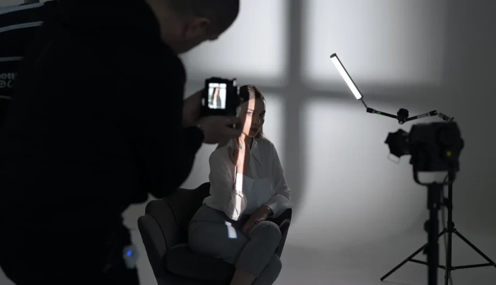 Francesco Francia scatta una foto in studio con una modella illuminata parzialmente da una luce laterale.