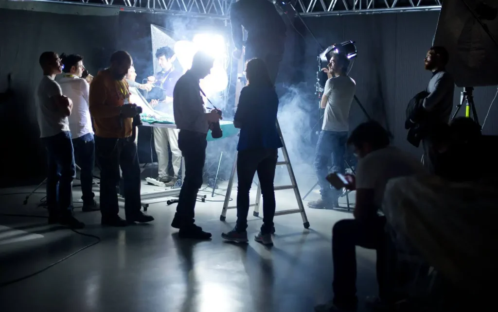 Gruppo di persone durante una sessione fotografica in studio con luci e fumo.