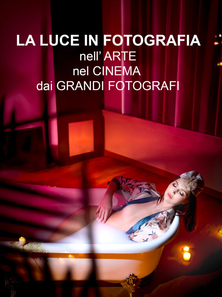Modella che fa il bagno in una vasca vintage piena di latte con abiti eleganti e con luci rosse di candele che simboleggia la luce in fotografia di Francesco Francia