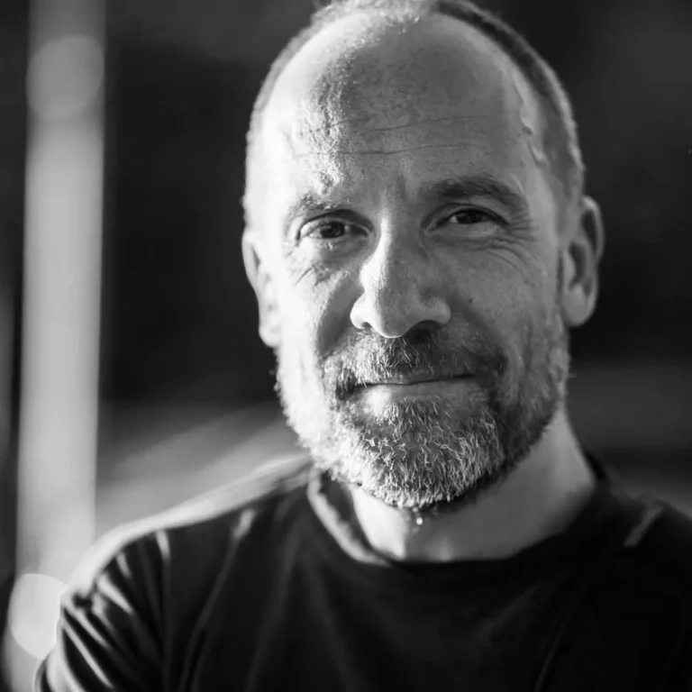 Ritratto di Davide Basta, videomaker e docente, in primo piano con sfondo neutro.